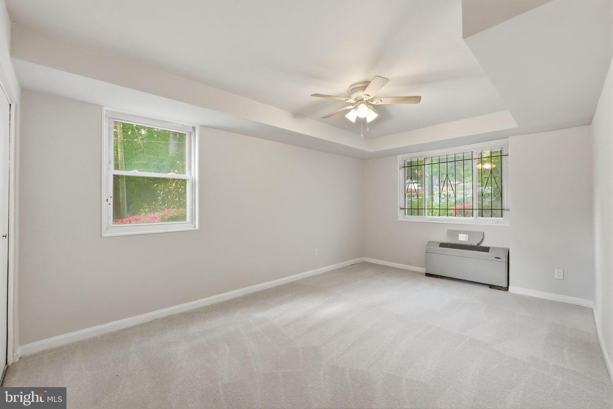 95 East Wayne Avenue, Unit 101 Silver Spring, MD 20901 - Photo 19 of 20 an empty room with a window and ceiling fan