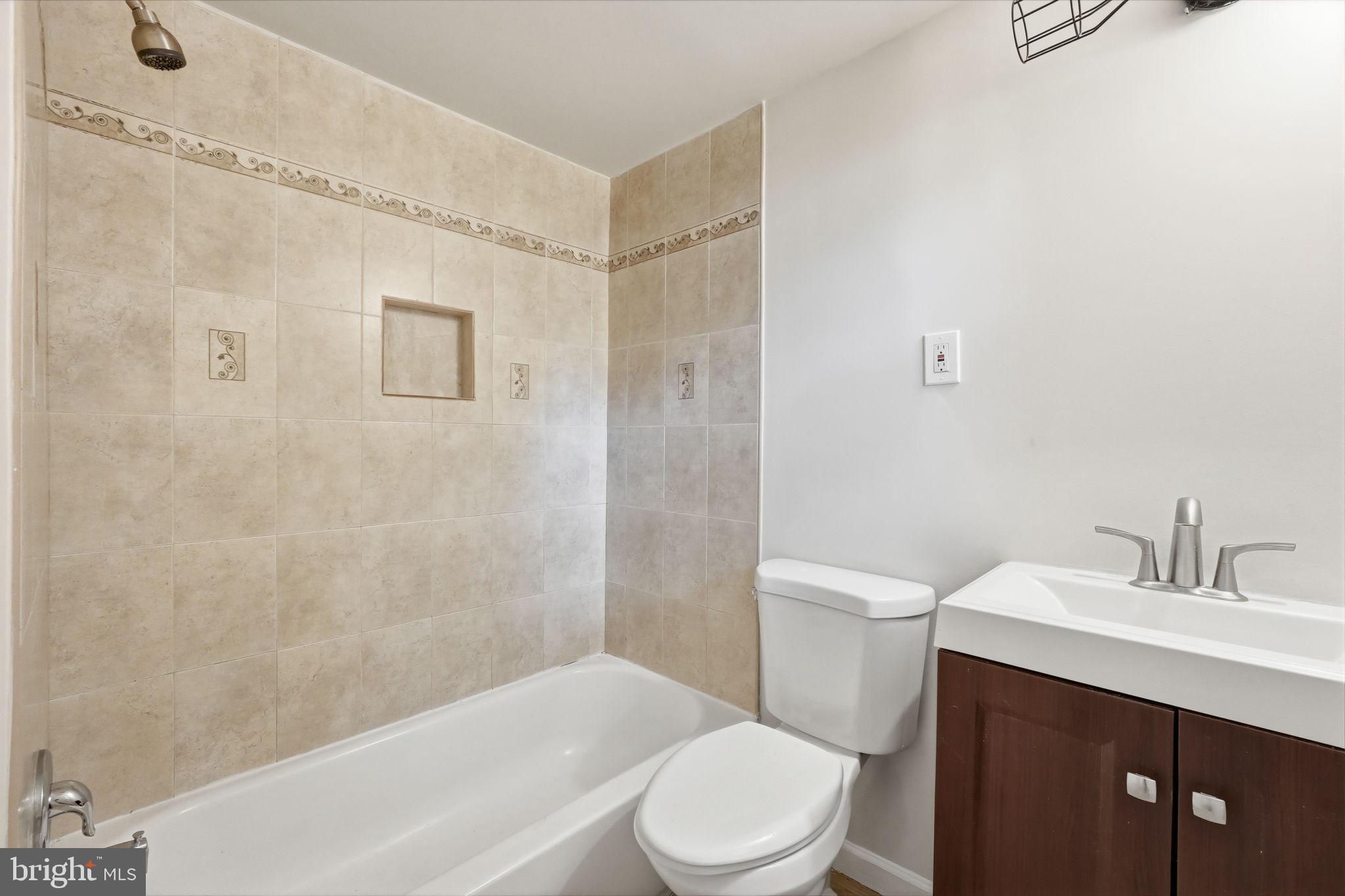 95 East Wayne Avenue, Unit 101 Silver Spring, MD 20901 - Photo 9 of 20 a bathroom with a sink a toilet and shower