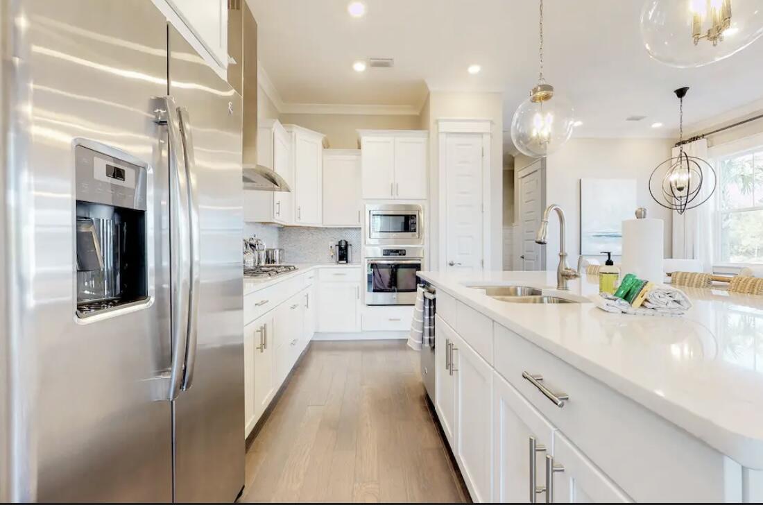 106 York Ln Inlet Beach, Unit A Inlet Beach, FL 32461 - Photo 5 of 28 a large white kitchen with lots of counter space wooden floor and stainless steel appliances