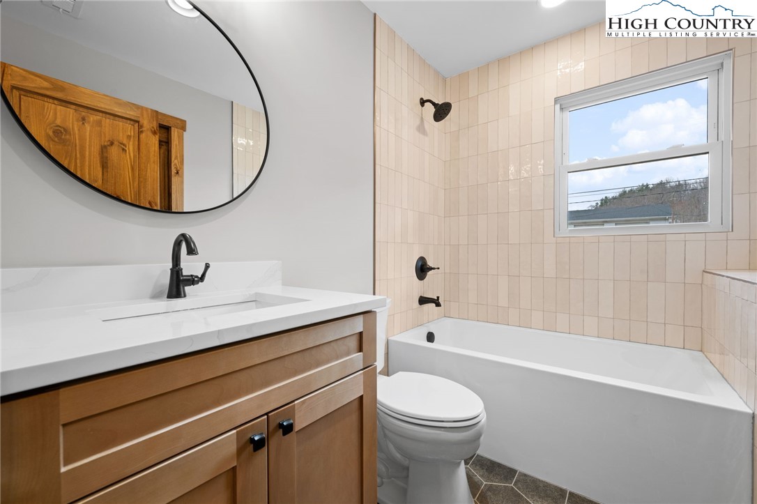 1904 Highway 194 Boone, NC 28607 - Photo 16 of 29 a bathroom with a sink a toilet and a mirror