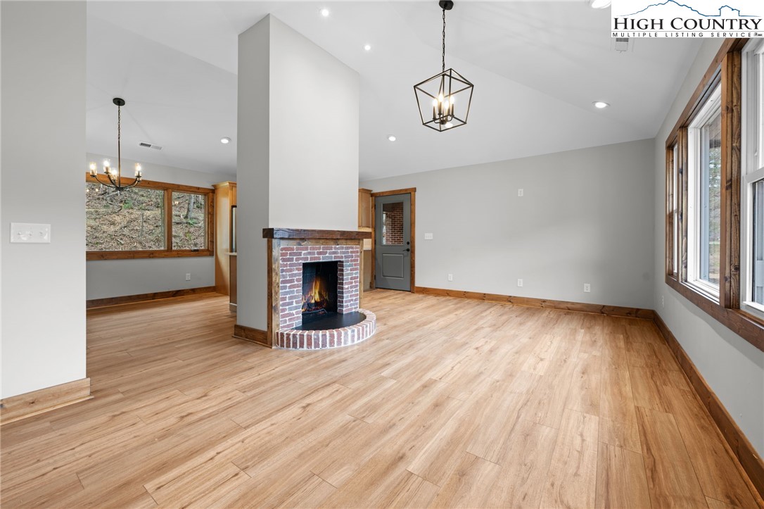 1904 Highway 194 Boone, NC 28607 - Photo 4 of 29 a view of an empty room with wooden floor fireplace and a window