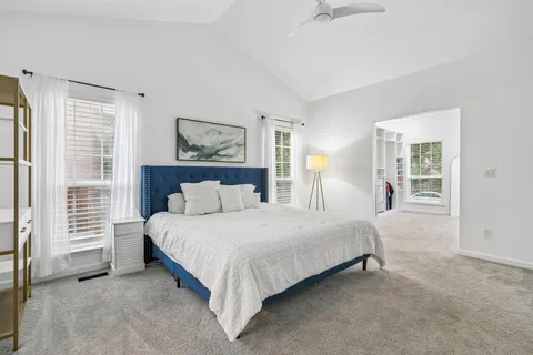 a bedroom with a bed painting and a window