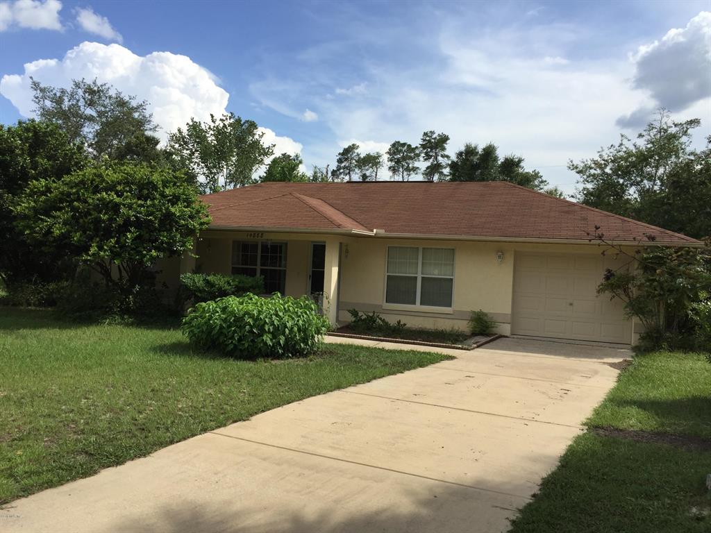 a front view of a house with a garden and yard
