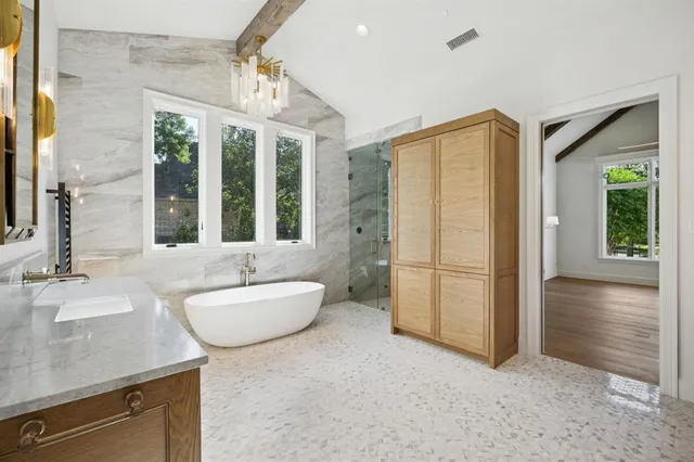 a spacious bathroom with a sink a mirror and a shower