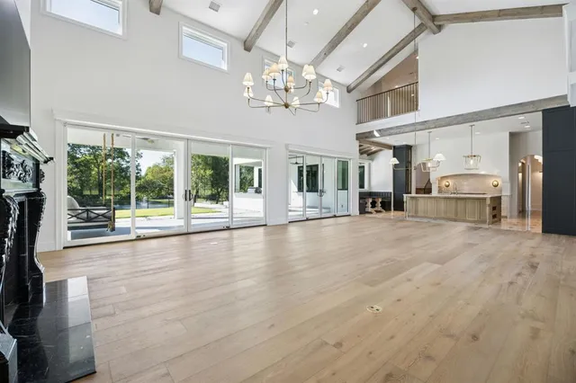 a view of an empty room with a fireplace and chandelier