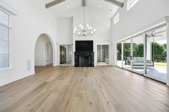 a view of an empty room with a fireplace and a window