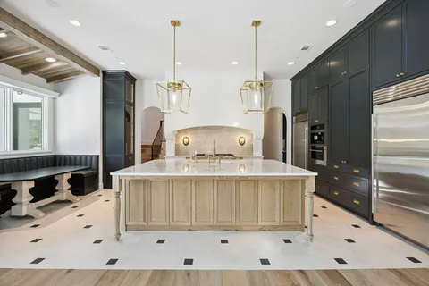 a view of kitchen with stainless steel appliances granite countertop cabinets and a wooden floor