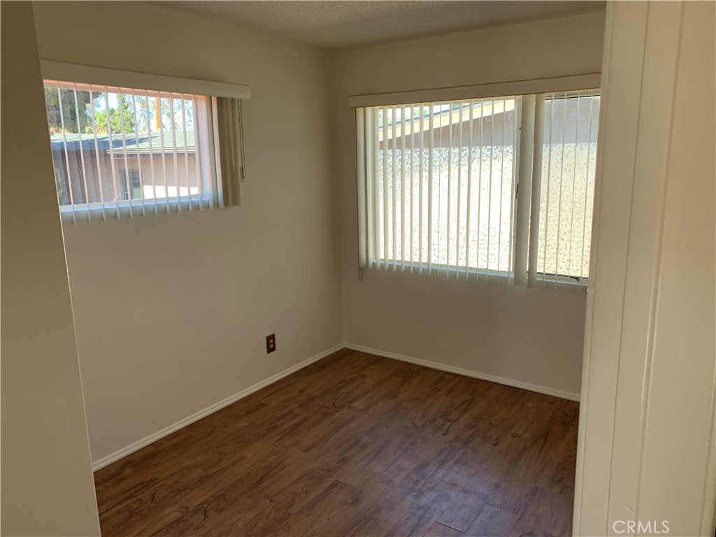 309 Avenida Victoria, Unit B San Clemente, CA 92672 - Photo 5 of 8 an empty room with wooden floor and windows