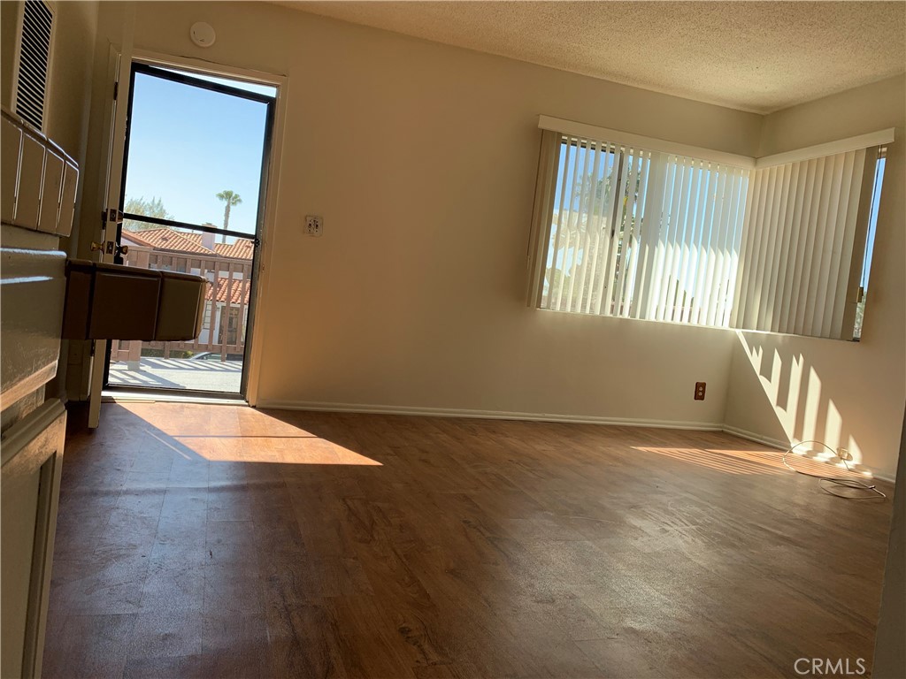 309 Avenida Victoria, Unit B San Clemente, CA 92672 - Photo 8 of 8 a view of an empty room with window and wooden floor