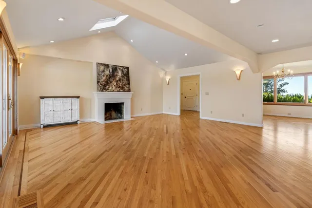 an empty room with wooden floor and fireplace