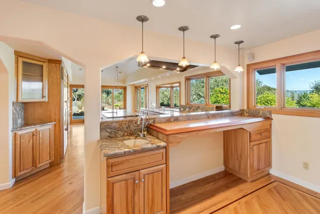 a kitchen with stainless steel appliances granite countertop a stove and a wooden floors