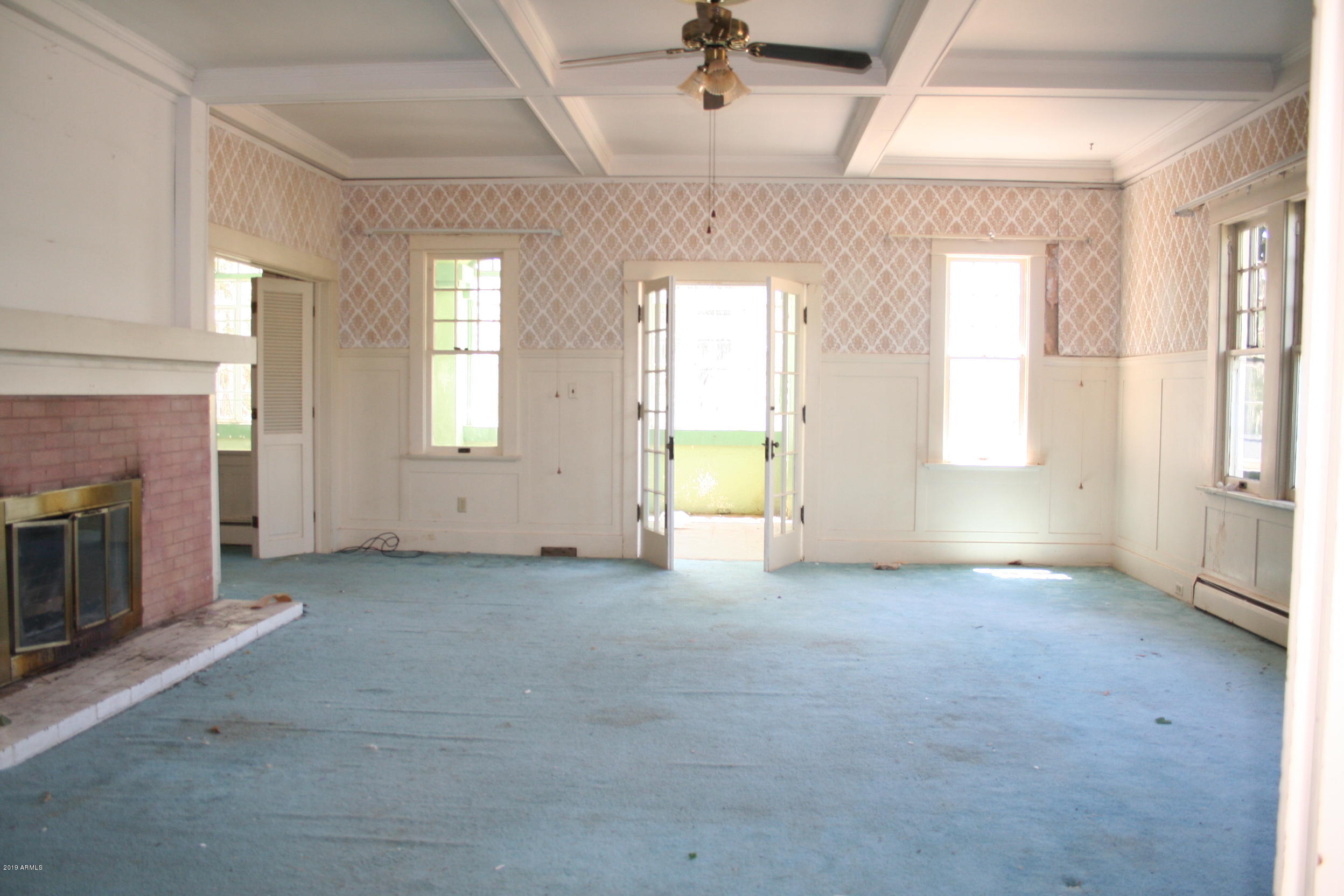 200 E Vista Bisbee, AZ 85603 - Photo 17 of 96 an empty room with windows and fireplace
