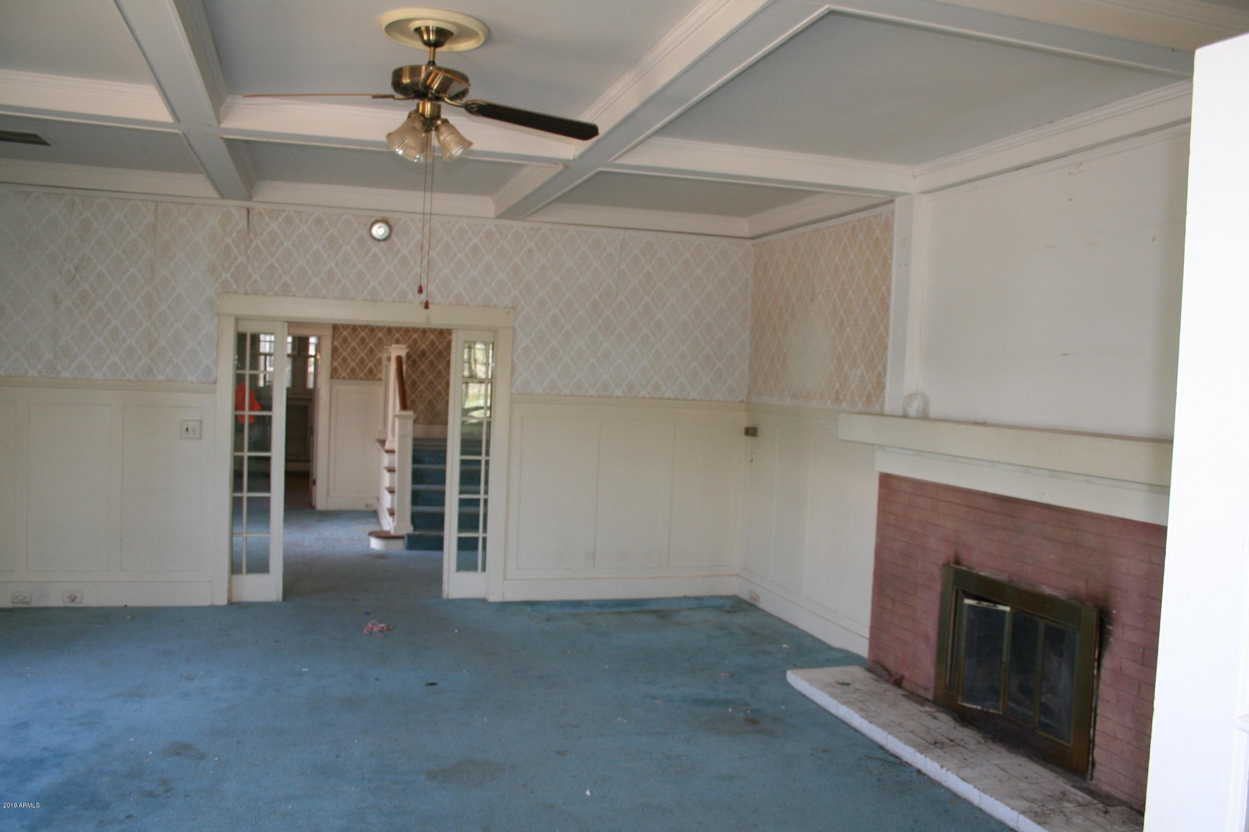 200 E Vista Bisbee, AZ 85603 - Photo 18 of 96 an empty room with fireplace and fan