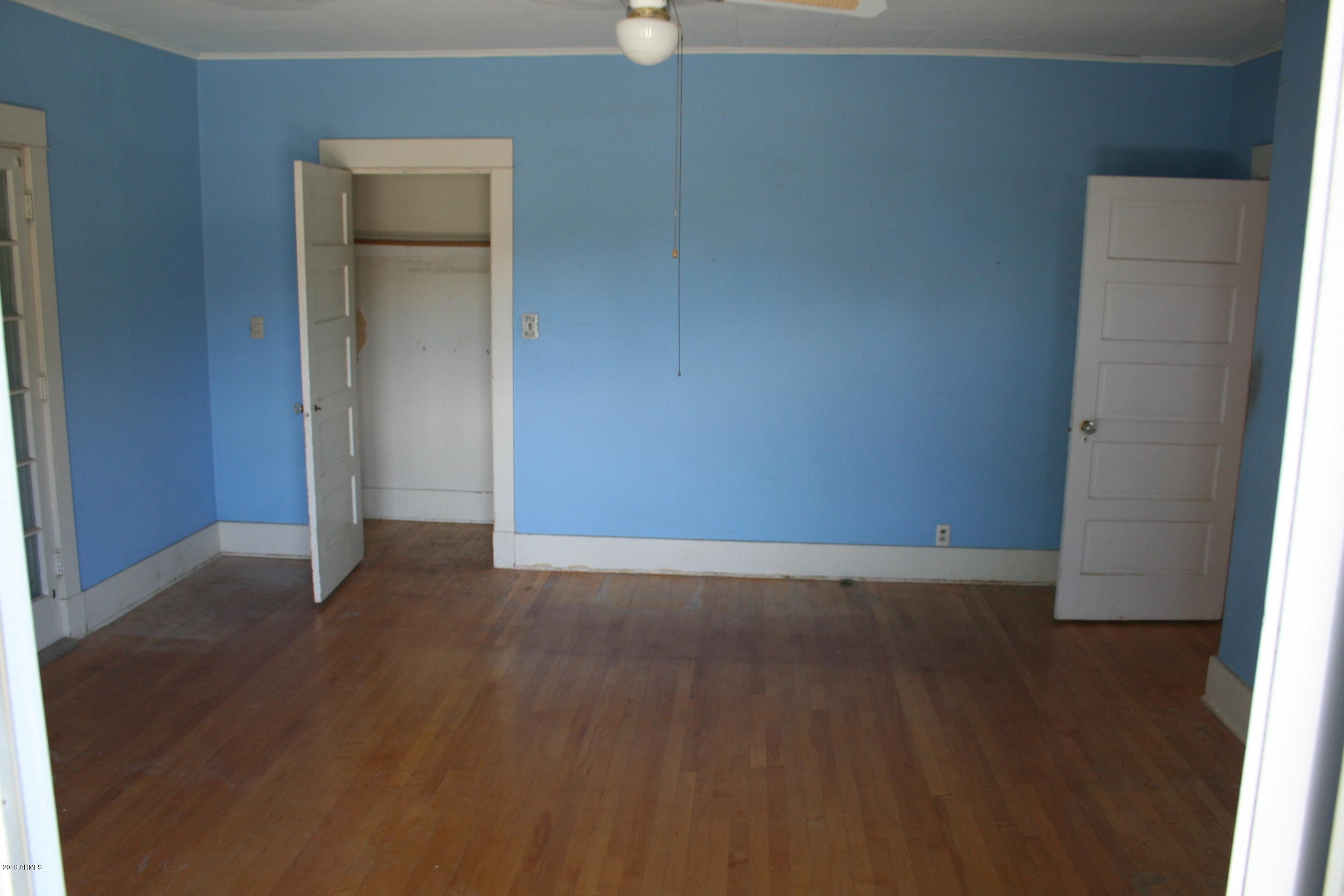 200 E Vista Bisbee, AZ 85603 - Photo 46 of 96 an empty room with wooden floor and cabinet