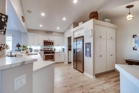 a kitchen with granite countertop a sink stainless steel appliances and cabinets