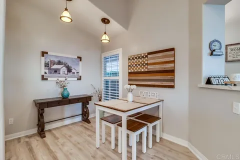 a kitchen with white cabinets a sink dishwasher and a stove with wooden floor