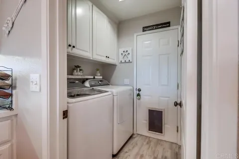 a kitchen with stainless steel appliances kitchen island granite countertop a dining table chairs and a refrigerator