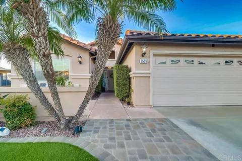 a patio with glass top table and chairs