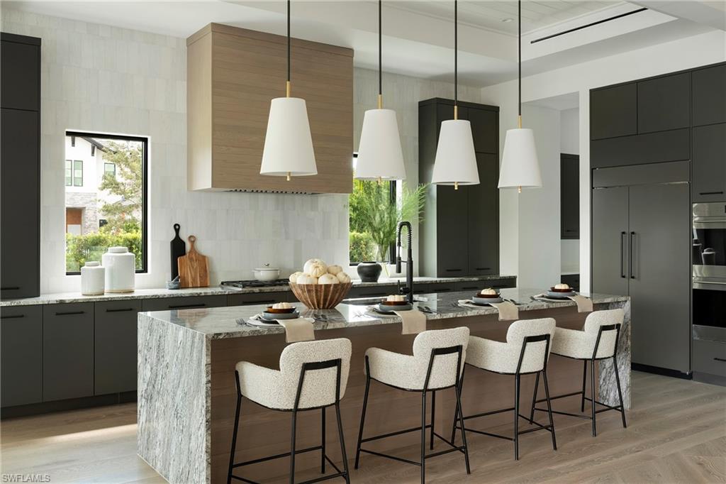 6704 Newport Road Naples, FL 34109 - Photo 10 of 47 a kitchen with a table chairs sink and cabinets