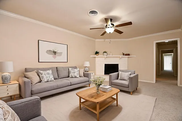 a living room with furniture a fireplace and a flat screen tv
