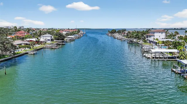 a view of a brick house with wooden fence and trees