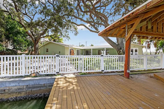 an aerial view of ocean and residential houses with outdoor space