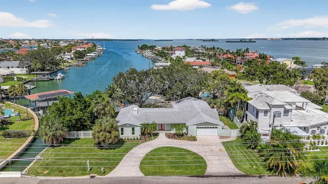an aerial view of a city with lots of residential buildings ocean and mountain view in back