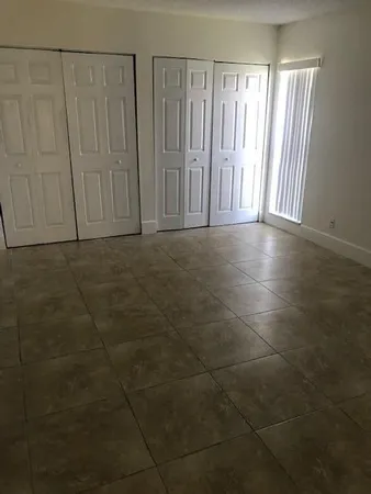 a view of a livingroom with an empty space and a window