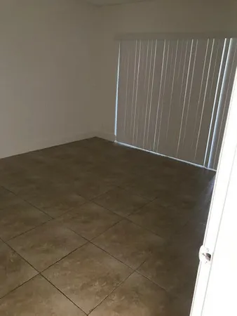 a bathroom with a toilet a sink a window and shower