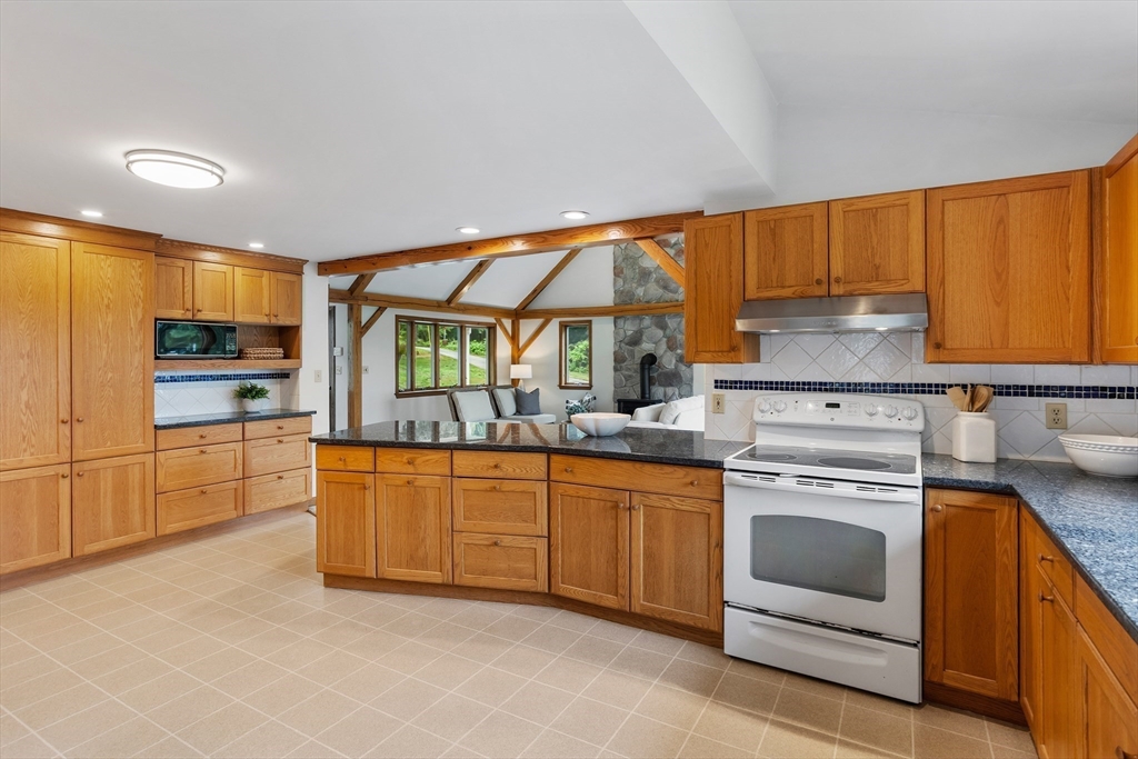 444 Middle Road Boxborough, MA 01719 - Photo 12 of 42 a kitchen with granite countertop a sink stove and cabinets
