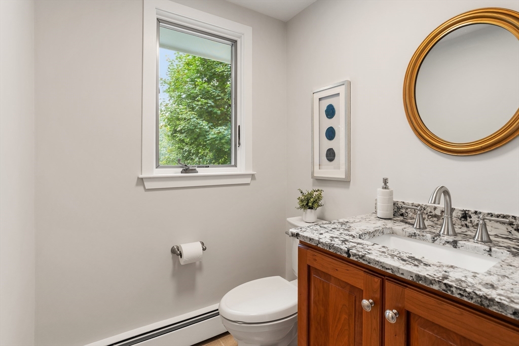 444 Middle Road Boxborough, MA 01719 - Photo 17 of 42 a bathroom with a granite countertop toilet a sink and a mirror
