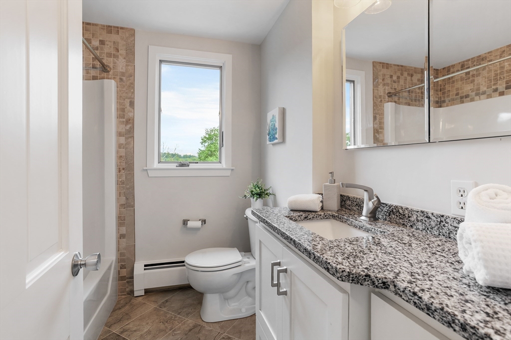 444 Middle Road Boxborough, MA 01719 - Photo 24 of 42 a bathroom with a granite countertop sink a toilet and a mirror