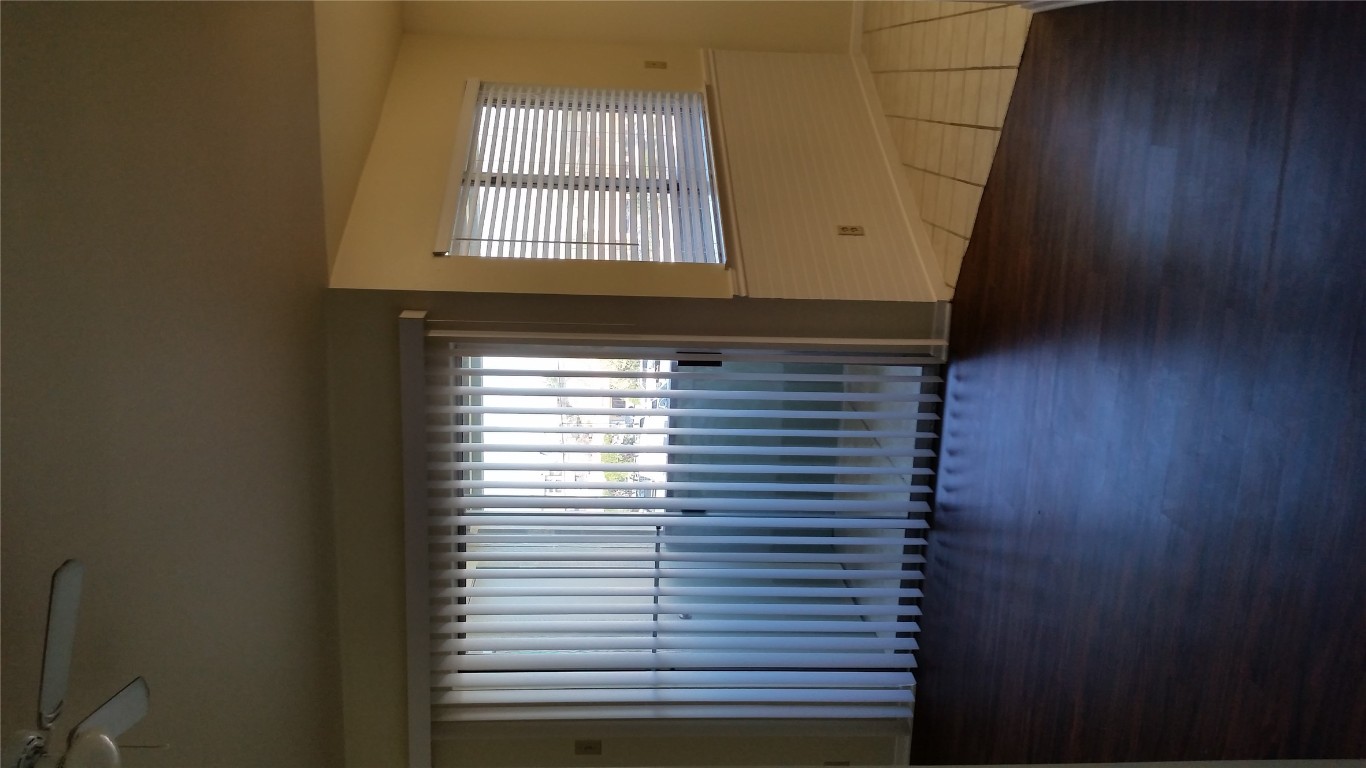 6809 West Gate Boulevard, Unit 203 Austin, TX 78745 - Photo 12 of 12 Unfurnished room featuring wood finished floors and ceiling fan