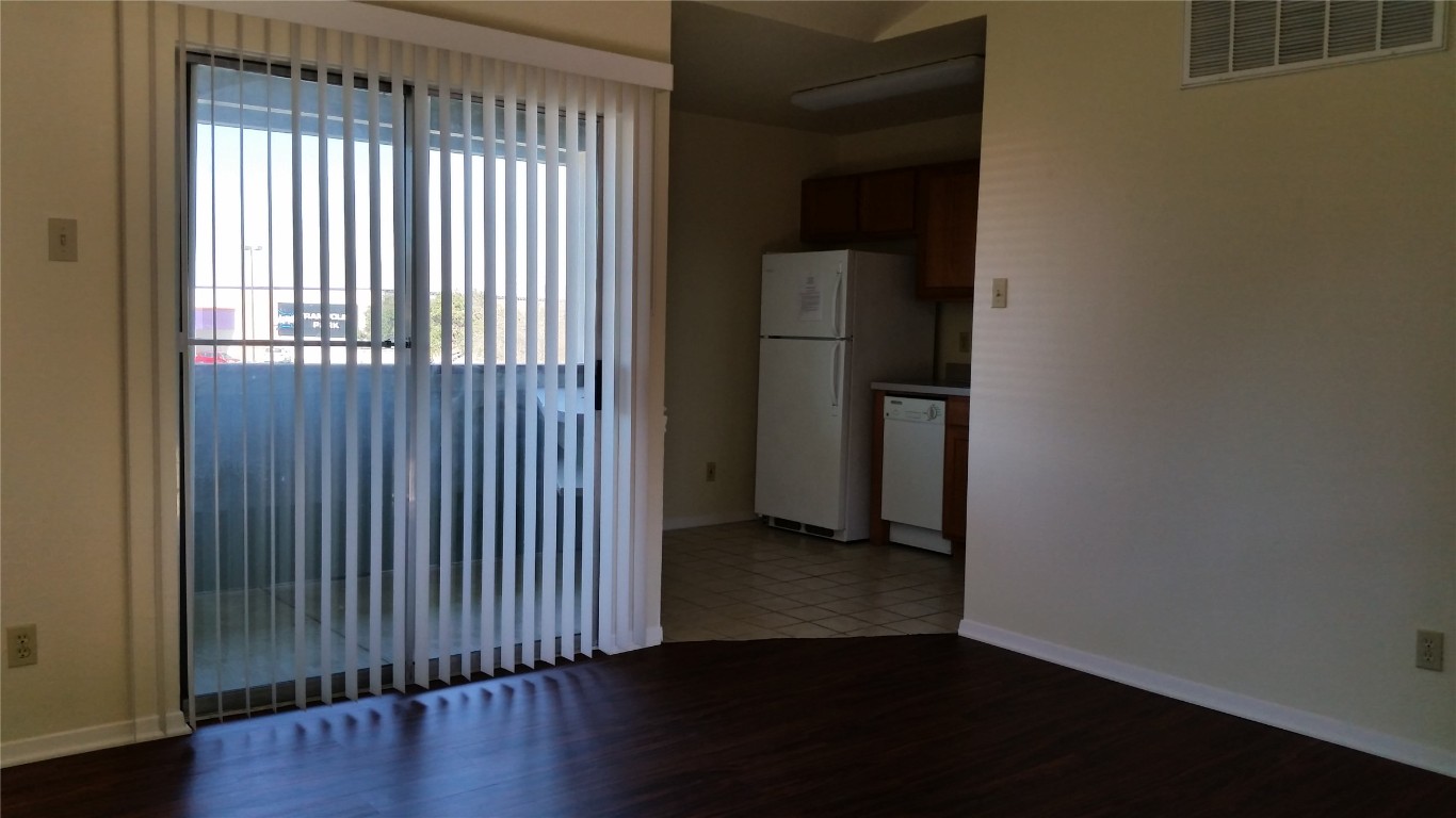 6809 West Gate Boulevard, Unit 203 Austin, TX 78745 - Photo 5 of 12 Unfurnished room featuring dark wood finished floors and baseboards