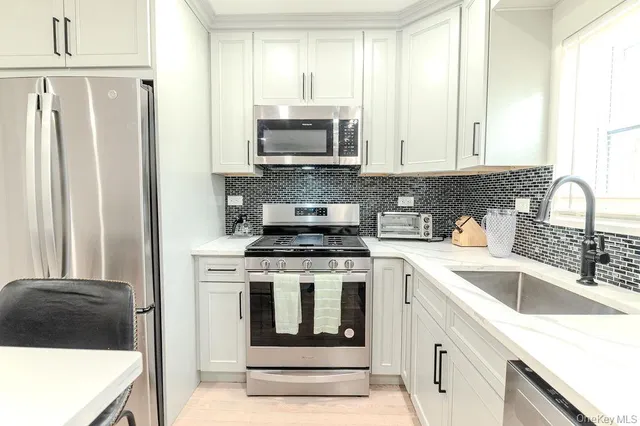 a living room with furniture kitchen view and a window