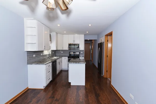 a kitchen with a refrigerator and a stove top oven
