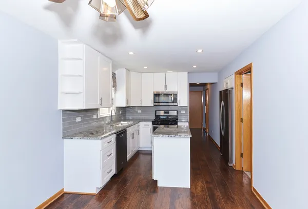 a kitchen with a center island wooden floor cabinets and appliances