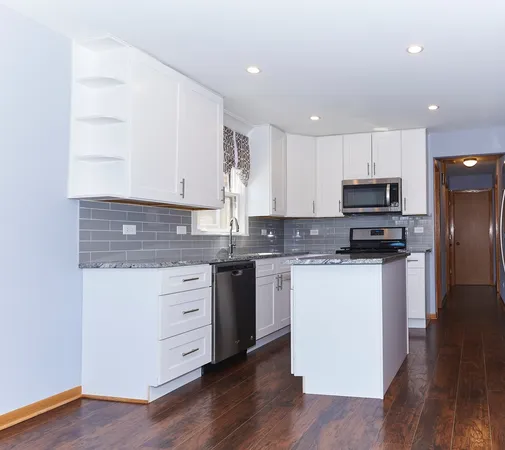 a kitchen with granite countertop white cabinets and white appliances