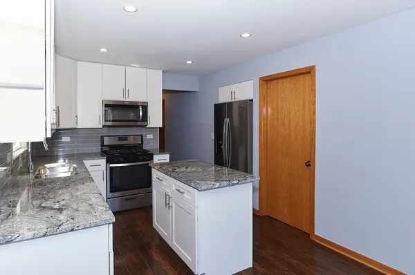 a kitchen with a refrigerator a microwave a sink and a stove