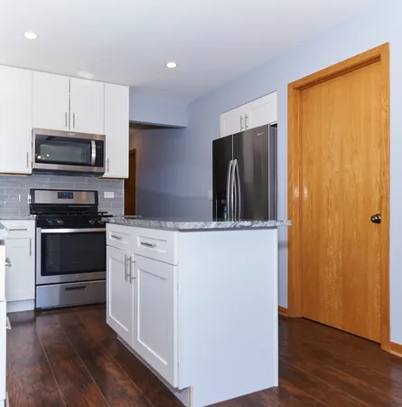 a kitchen with stainless steel appliances a refrigerator and a stove top oven