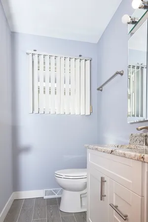 a bathroom with a sink a toilet and a window