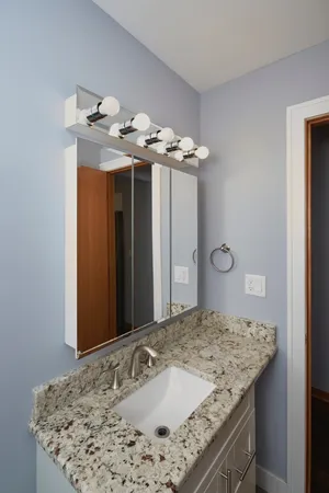 a bathroom with a granite countertop sink and a mirror