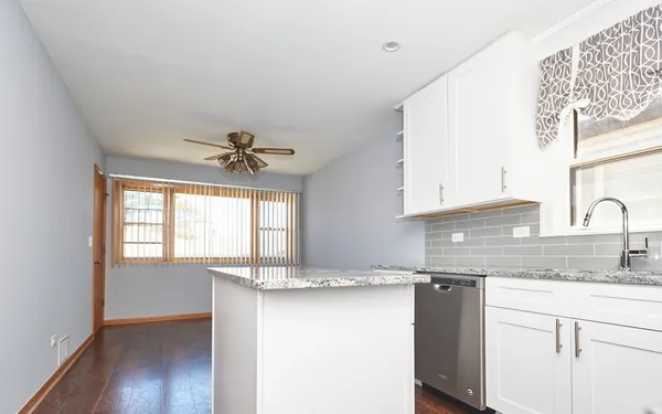 a kitchen with granite countertop a sink cabinets and window