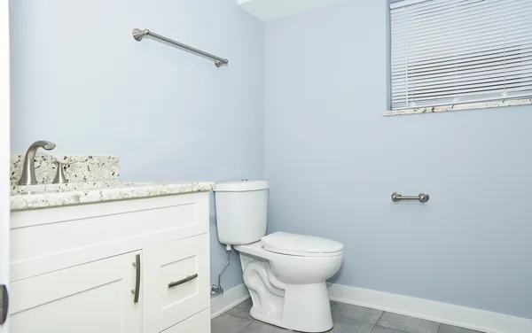 a bathroom with a toilet sink and mirror