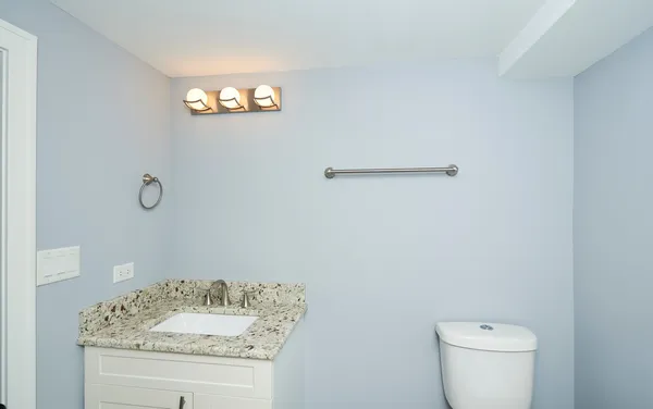 a bathroom with a sink a toilet and a mirror