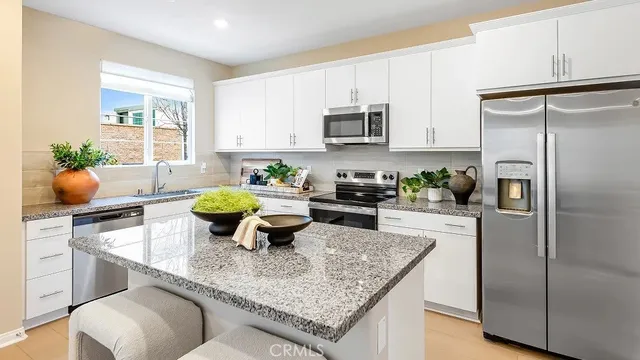 a kitchen with stainless steel appliances granite countertop a sink a stove and a refrigerator
