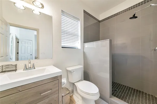 a bathroom with a granite countertop sink a toilet and a mirror