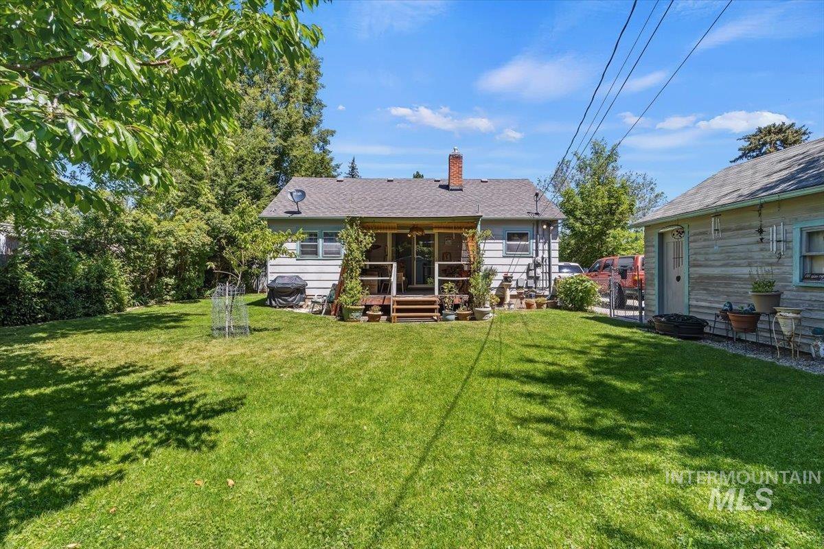 4619 Freemont Street Boise, ID 83706 - Photo 18 of 27 Expansive rear yard featuring a manicured lawn, screened porch with wood decking, and a detached structure