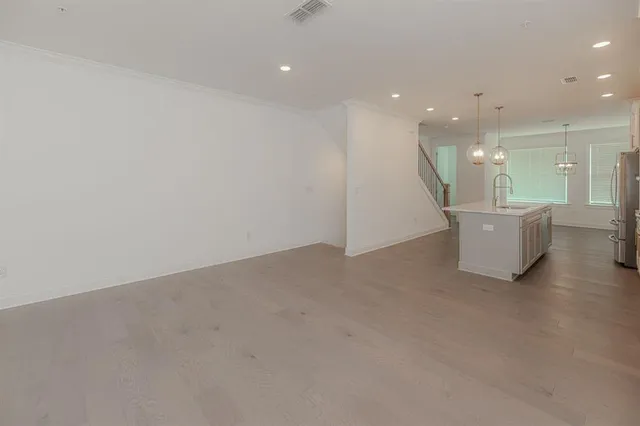 a large kitchen with stainless steel appliances a large counter top a stove a refrigerator and a sink