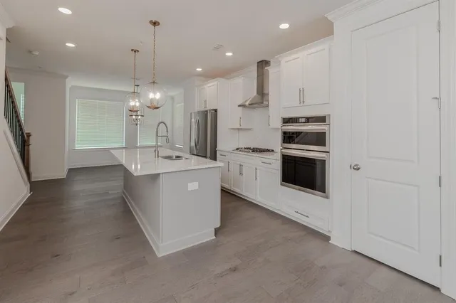a large kitchen with a large counter top stainless steel appliances and cabinets